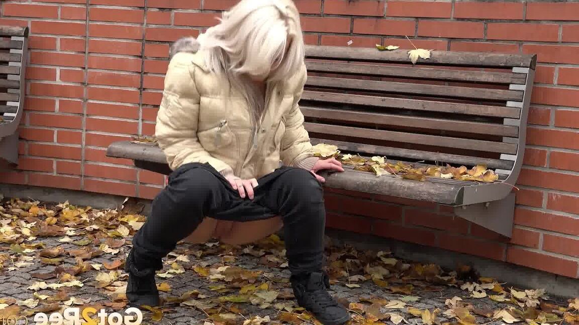 15P Clothed blonde Licky Lex pulls down dark leggings for a piss by a public bench