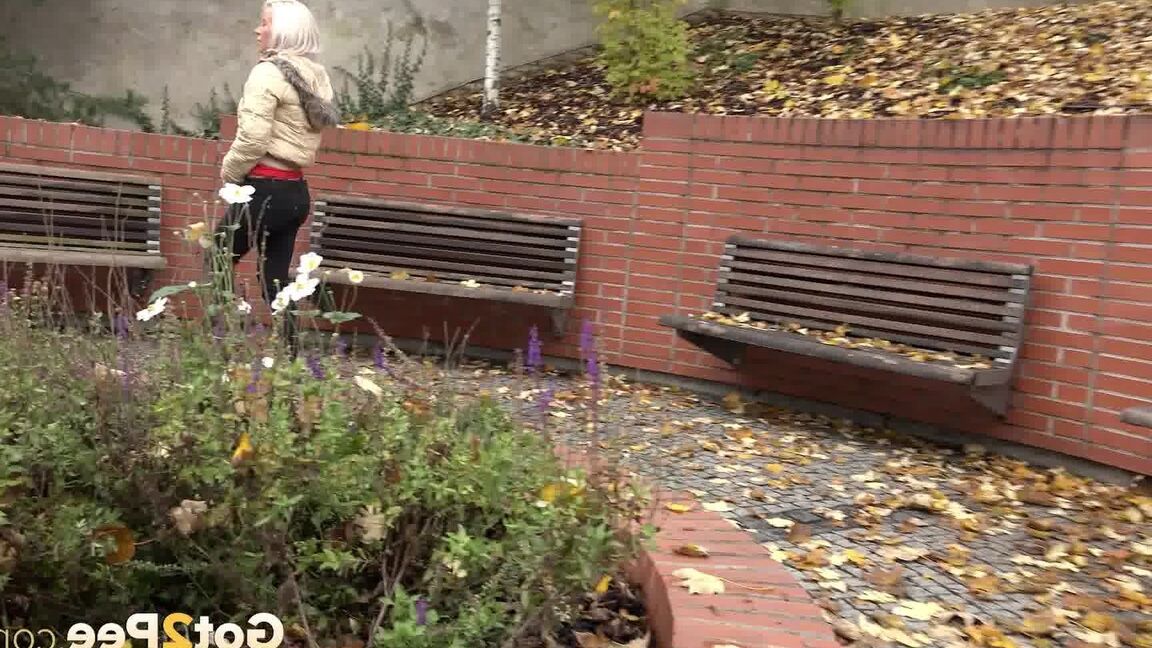 15P Clothed blonde Licky Lex pulls down dark leggings for a piss by a public bench