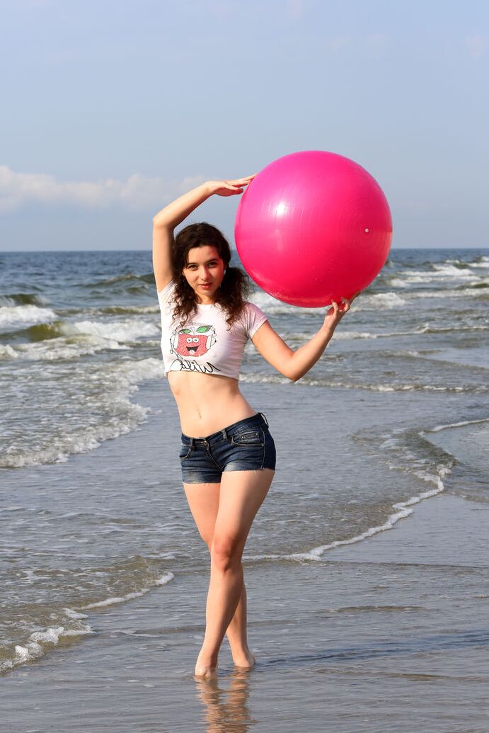 20P Cute brunette Jennifer plays with her pigtails while getting naked at a beach