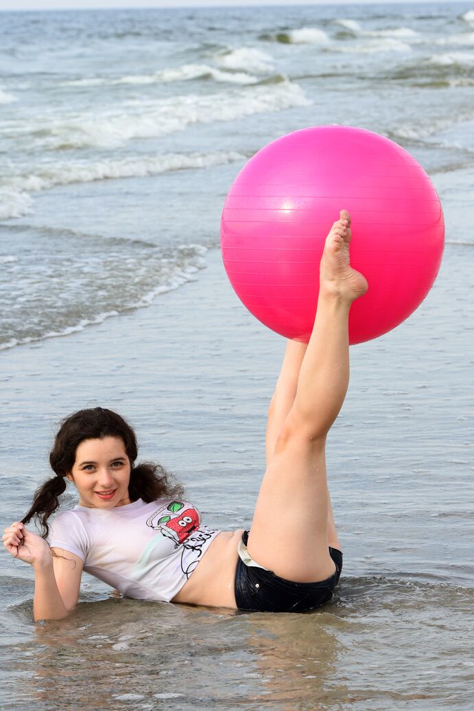 20P Cute brunette Jennifer plays with her pigtails while getting naked at a beach