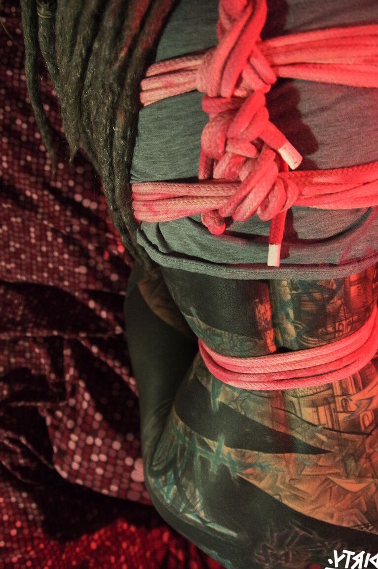10P Une femme fortement tatouée est attachée avec une corde rose avec ses lunettes