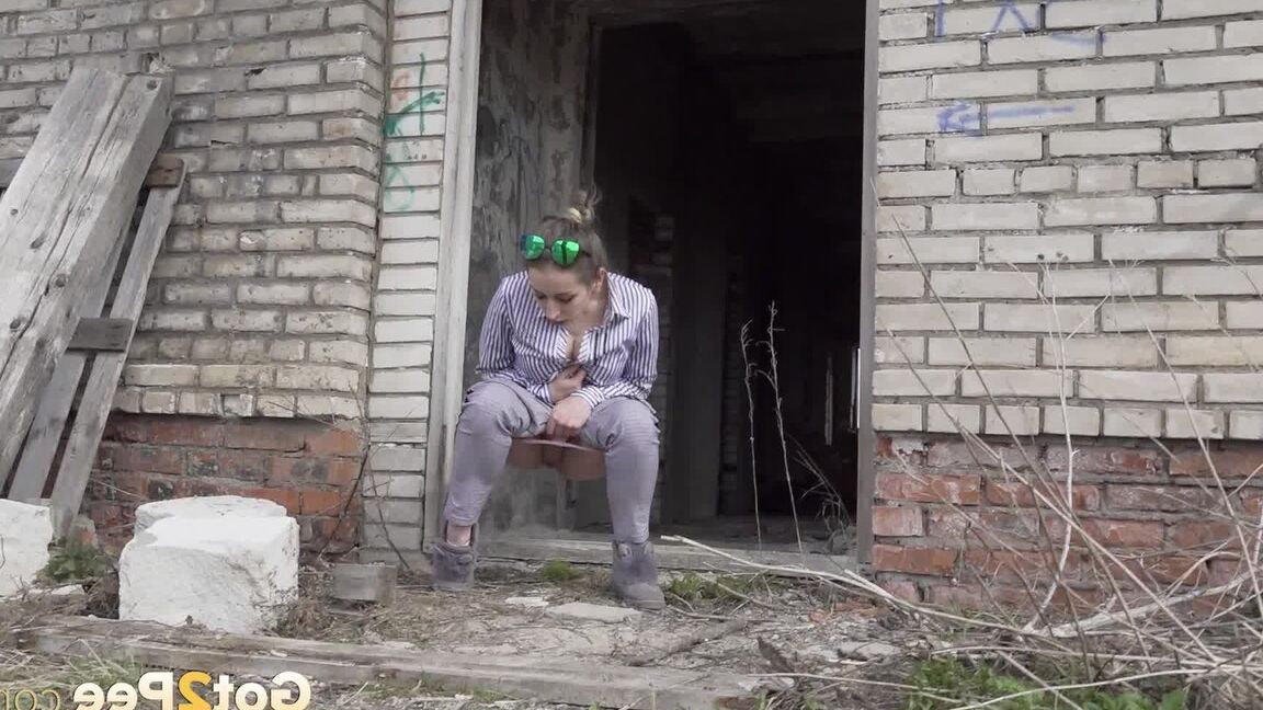 15P Брюнетка приседает возле заброшенного здания, чтобы пописать