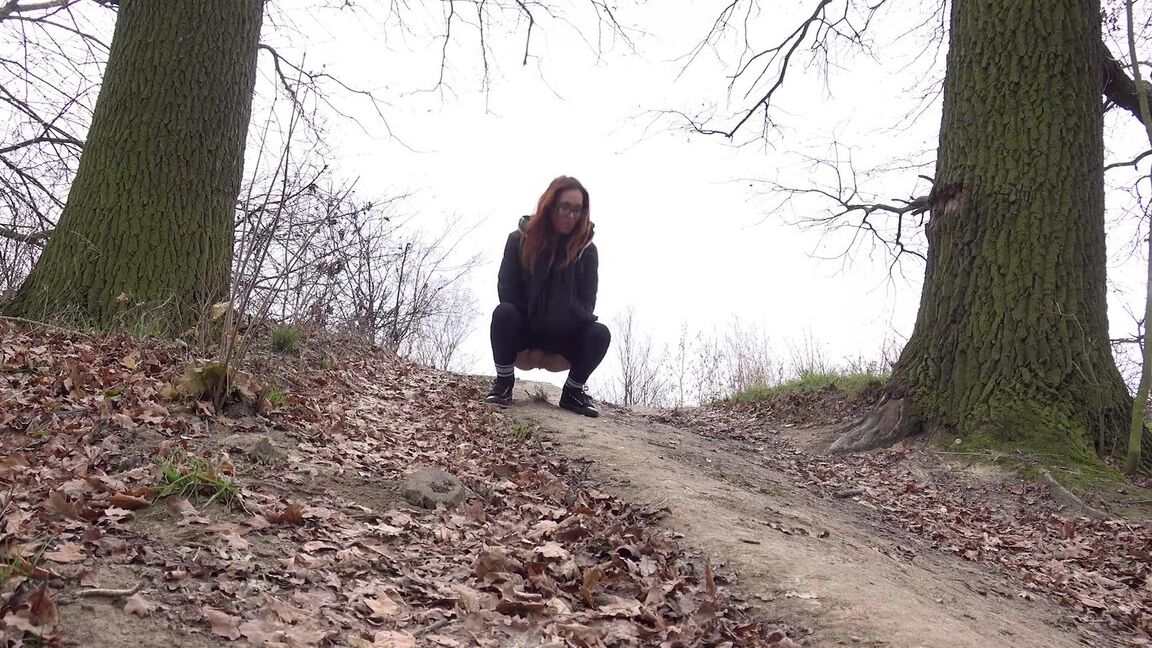 15P Redhead in glasses pees on a slope in the country