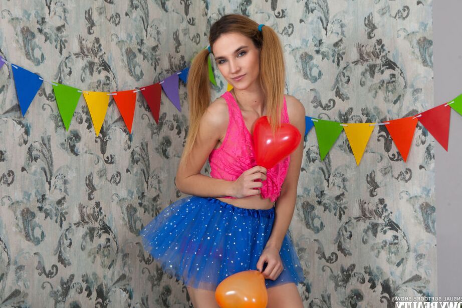 20P Impresionante chica pelirroja posando con una linda falda azul y una camisa rosa y sobresale