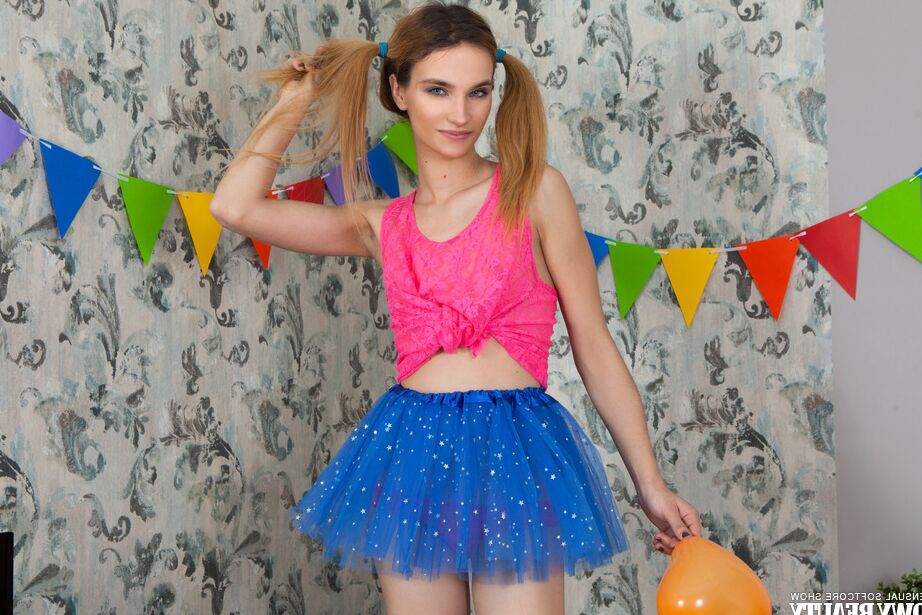 20P Impresionante chica pelirroja posando con una linda falda azul y una camisa rosa y sobresale