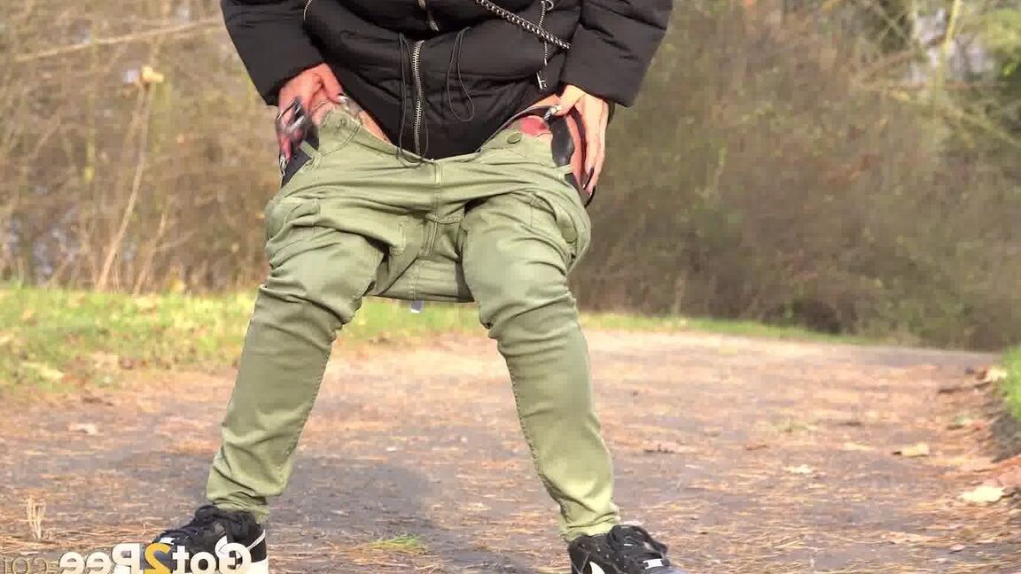 15P Clothed female Natasha Ink holds down her pants for a piss on a rural road