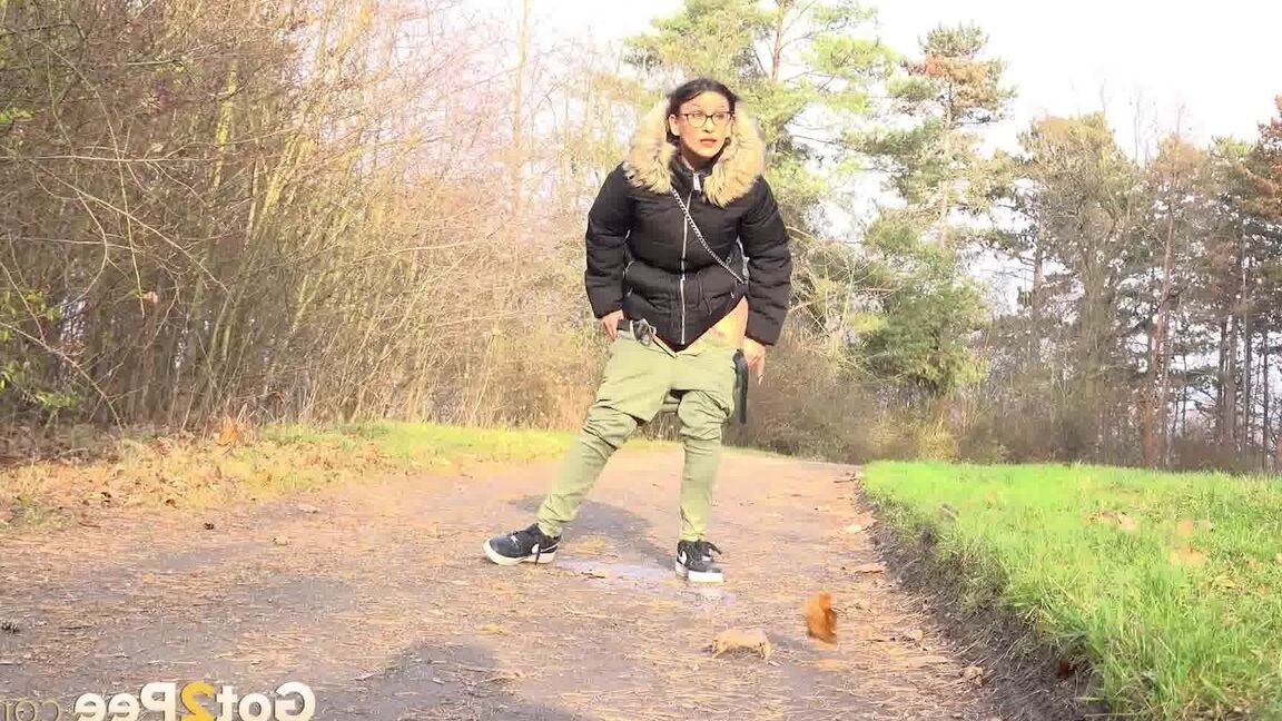 15P Clothed female Natasha Ink holds down her pants for a piss on a rural road