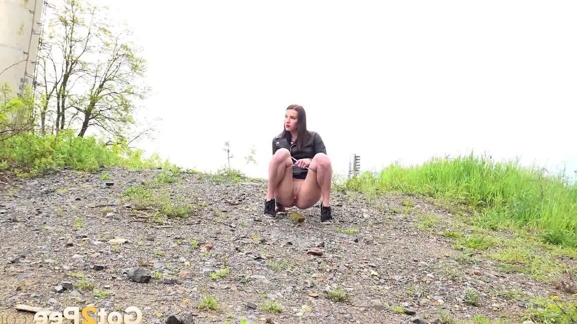 15P Solo girl Victoria Daniels hitches up her miniskirt to pee on a gravel path