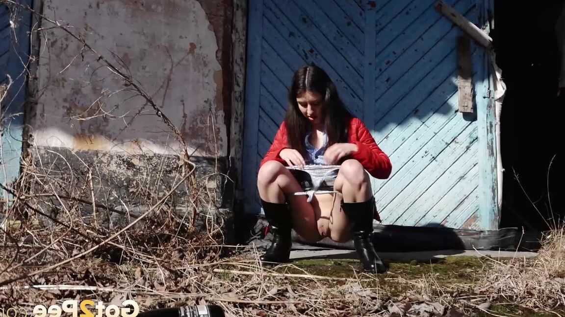 15P Brunette chick Katya squats for a piss behind a building in black boots