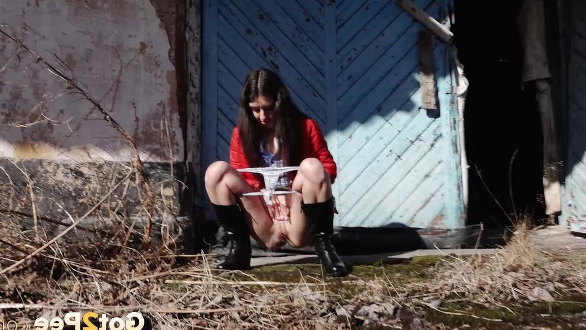 15P Brunette chick Katya squats for a piss behind a building in black boots