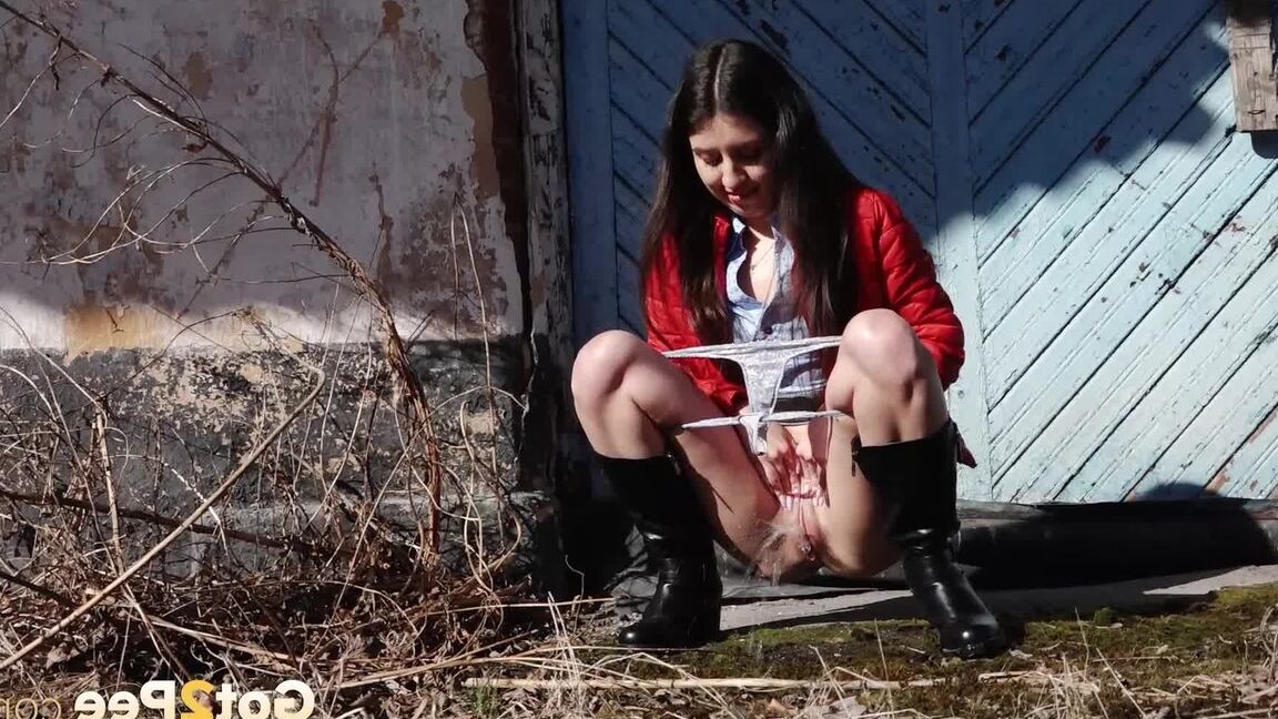15P Brunette chick Katya squats for a piss behind a building in black boots