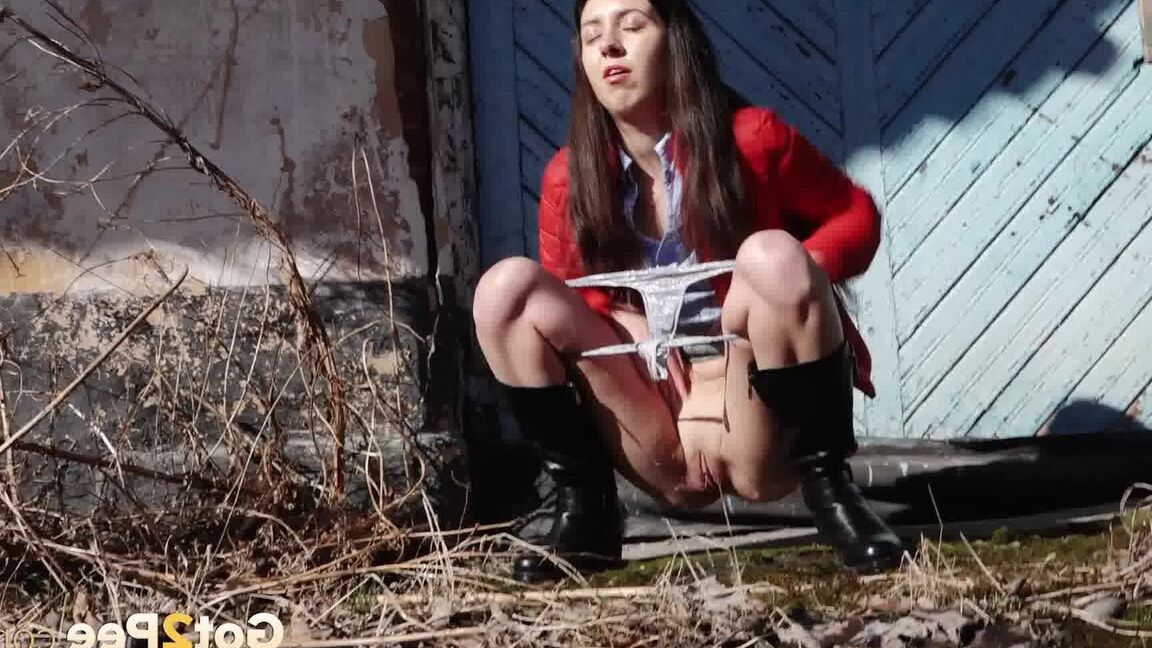 15P Brunette chick Katya squats for a piss behind a building in black boots