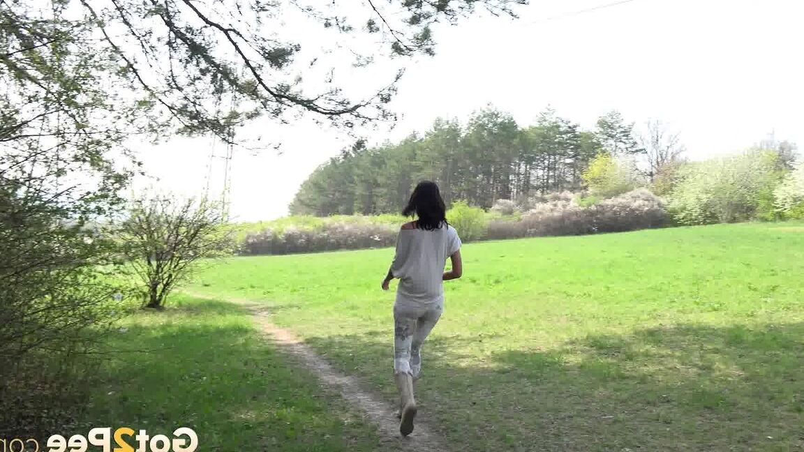 15P 黒髪の少女エヴリン・ニールがブーツを履いて土の道で小便をするためにしゃがむ