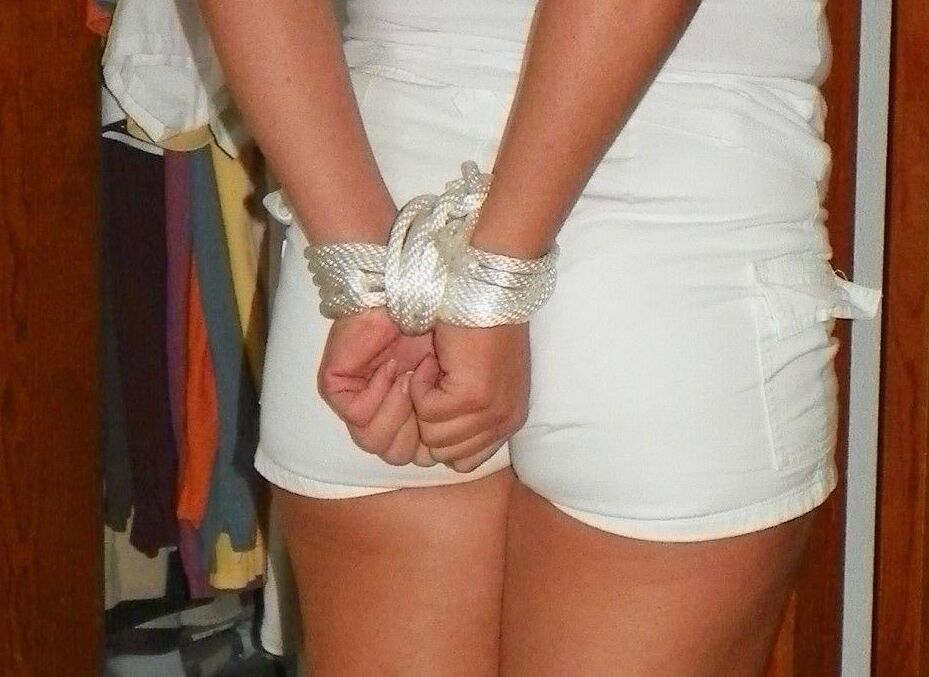 14P Amateur model is hogtied and gagged on a bed while fully clothed