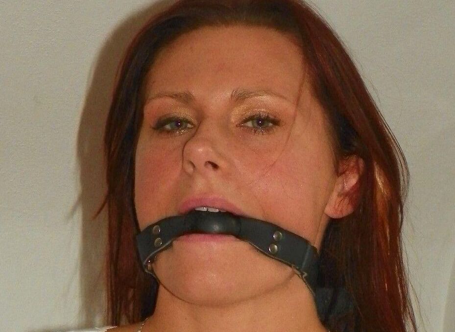 14P Amateur model is hogtied and gagged on a bed while fully clothed