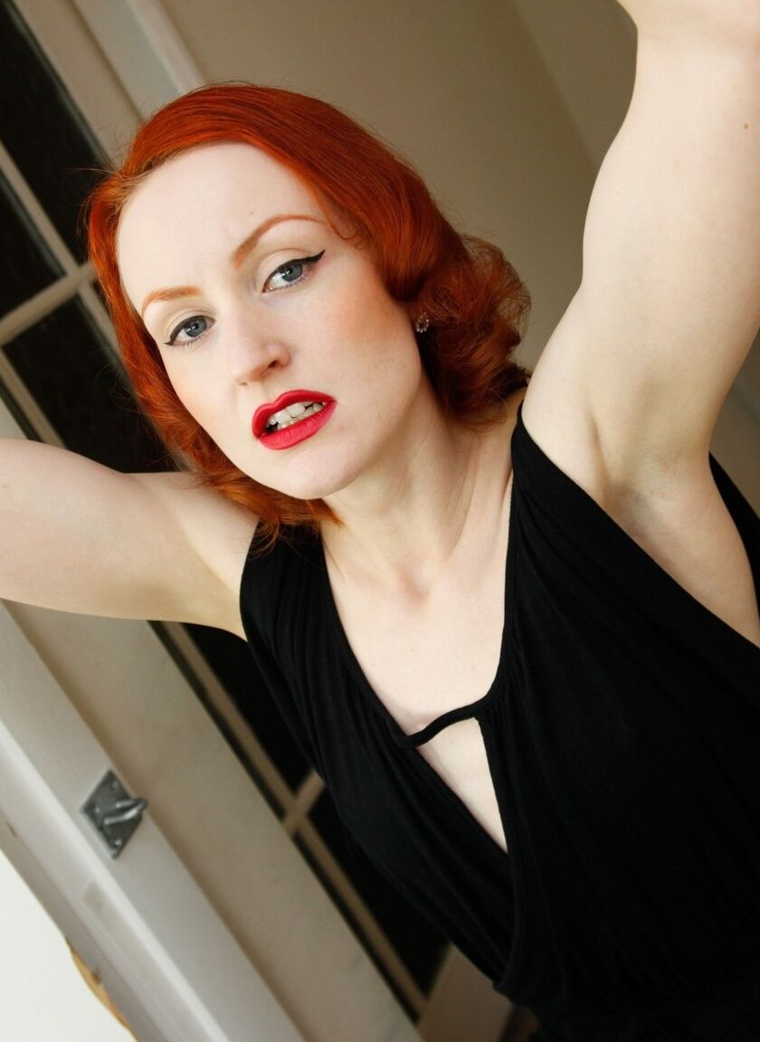 12P Pale redhead Anita De Bauch displays her hose covered feet in stocks