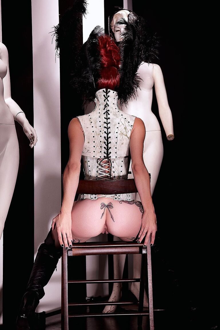 21P Glamour, Miss Crash, pose dans un corset en cuir qui révèle ses seins.