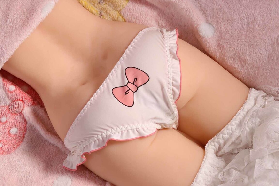 15P Brinquedo sexual feminino com torso de boneca sexual posado em uma linda calcinha branca em um cobertor