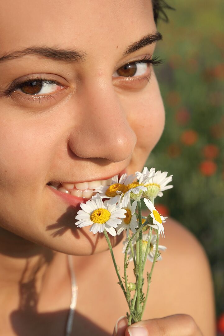 12P Chica solitaria de cabello oscuro se quita el vestido para modelar desnuda entre flores silvestres