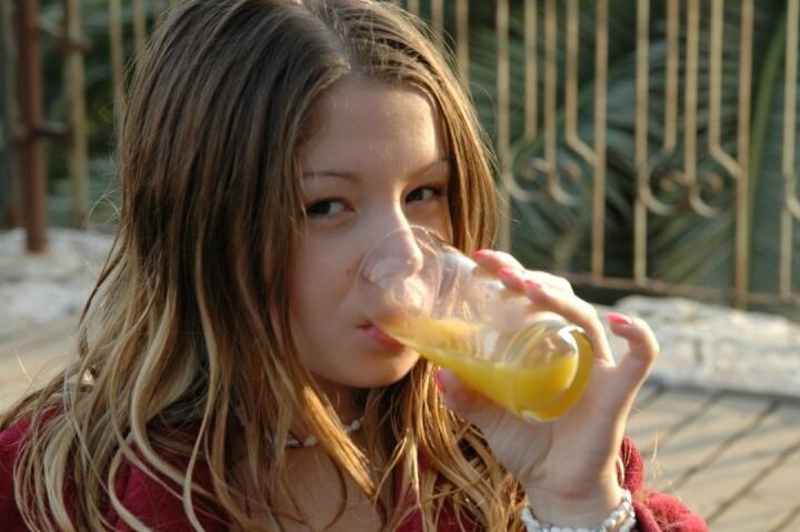 15P Jovem encantadora brinca em lingerie depois de um copo de suco de laranja no café da manhã