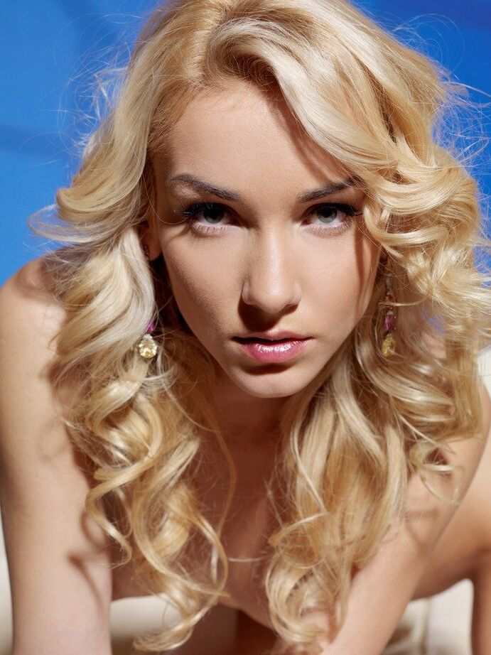 Das 18-jährige Solo-Mädchen Nataly F trägt lockiges blondes Haar und macht dabei sexy Posen