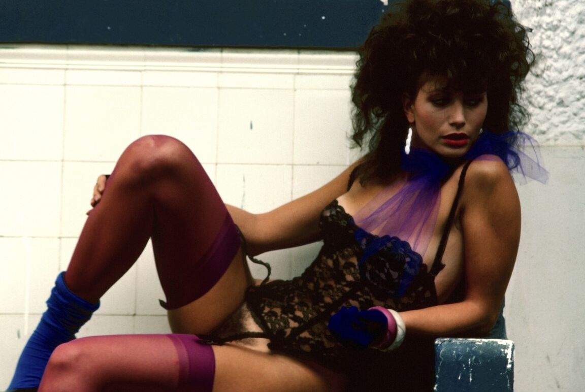 16P Antonia Larsen, une MILF brune et poilue, pose pour la caméra dans des tenues sexy.