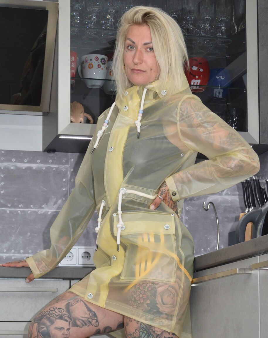 16P A loira tatuada Miss Francine modela descalça em uma capa de chuva sobre borracha