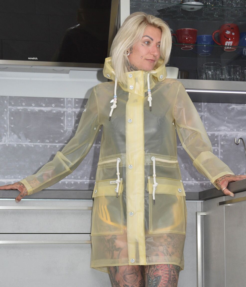 16P A loira tatuada Miss Francine modela descalça em uma capa de chuva sobre borracha