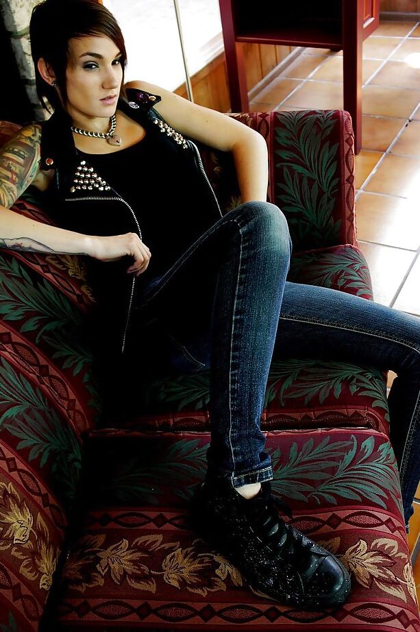 16P A estrela pornográfica de cabelos curtos Nikki Hearts posando totalmente vestida com jeans