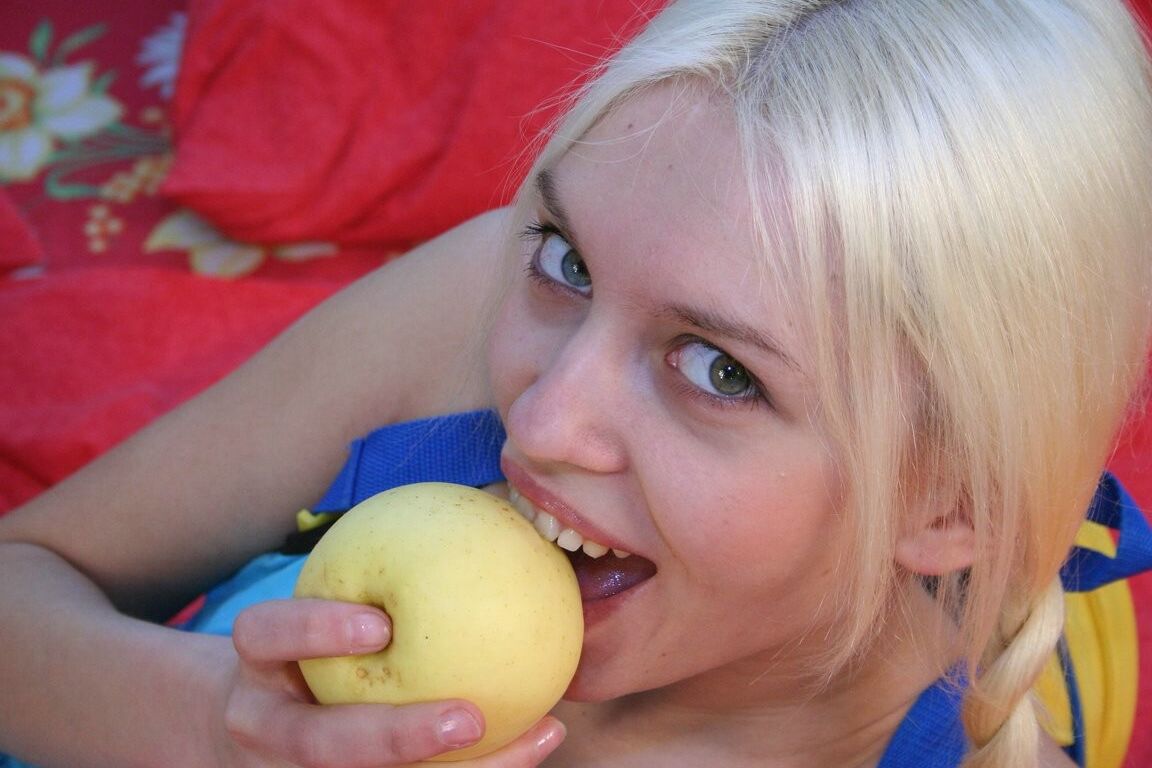 15P Young looking blonde eats a banana during close-up fucking on a bed