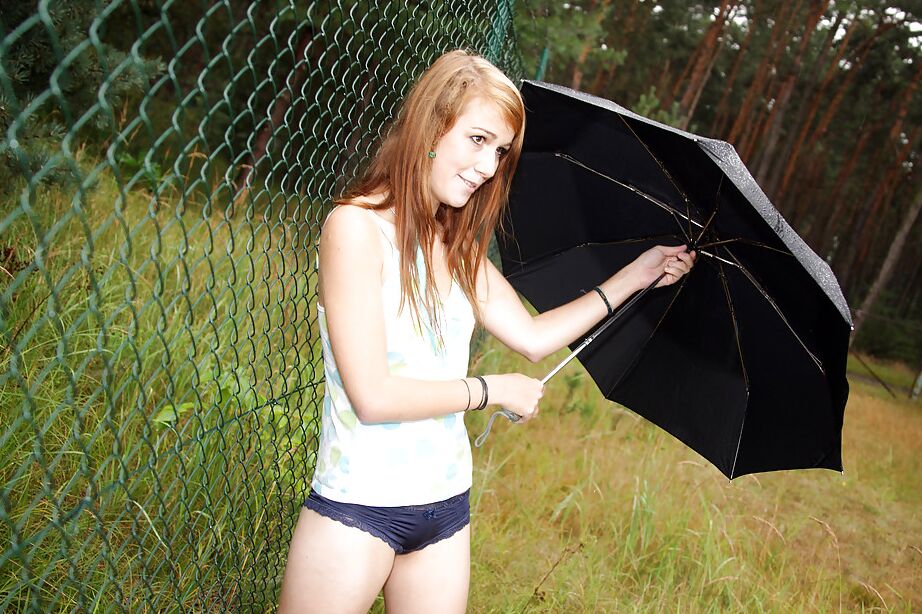 16P La encantadora adolescente Anouk al aire libre bajo la lluvia frotando su suave y abierto coño