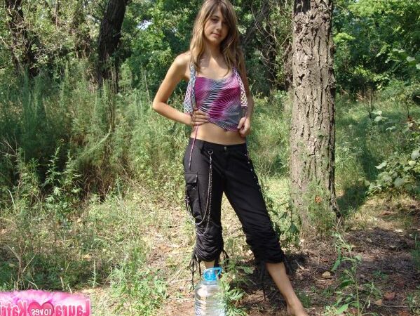 15P Adolescente amadora encharca seu corpo nu com uma jarra de água enquanto está perto da floresta