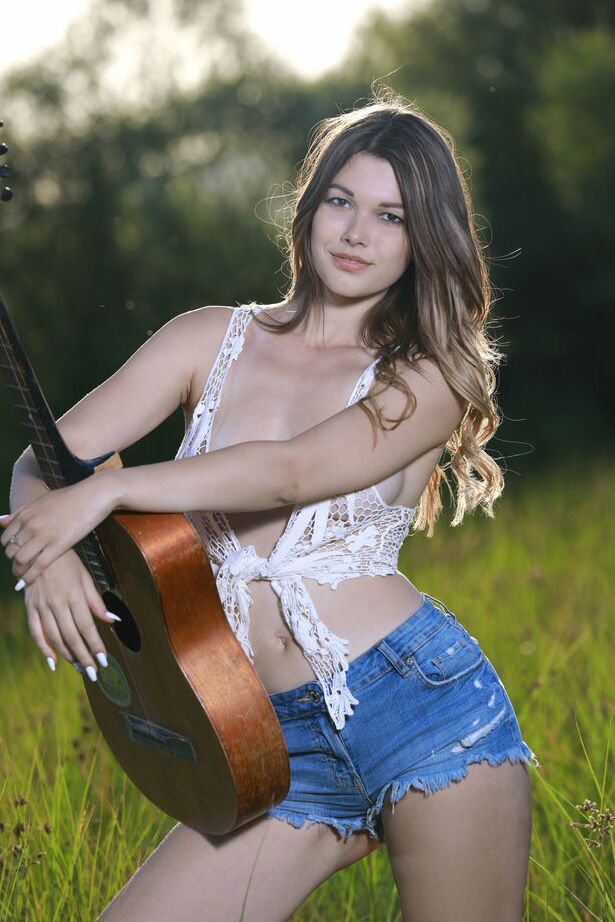 18P Nice teen Stefania Beatty gets totally naked in a field while playing guitar