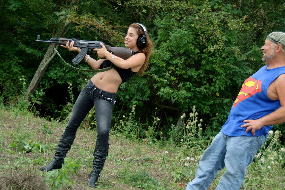 15P Latina chick Gigi Rivera fires a rifle in the woods after baring her tiny tits
