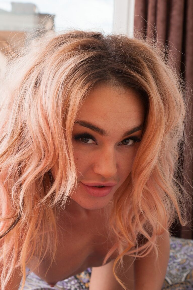 21P Lola, une fille séduisante à la chatte poilue, se déshabille et pose nue.