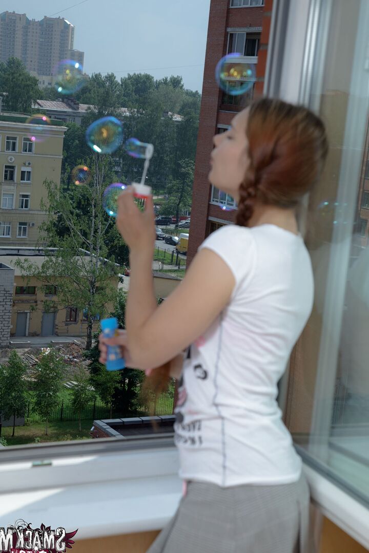 15P Playful teen Aurelia blows bubbles out the window and towards her man, who