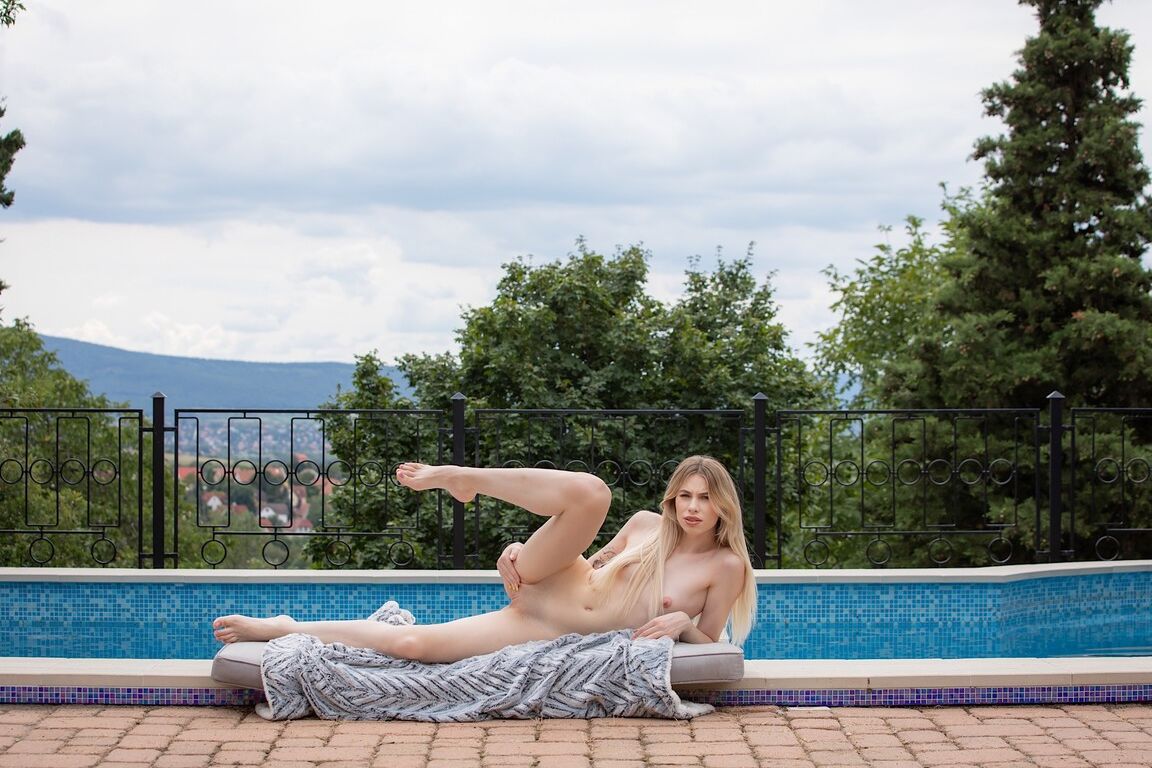 18P Young beauty Milena Devi gets totally naked on a mattress next to a pool