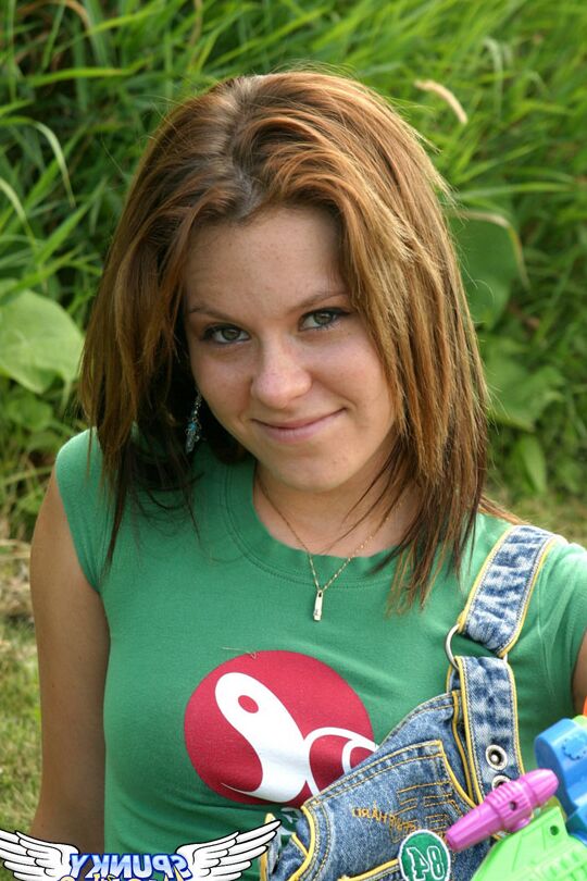 12P La mignonne érotique Kandie en jupe à bretelles montre une culotte en coton sous la jupe dans l'herbe