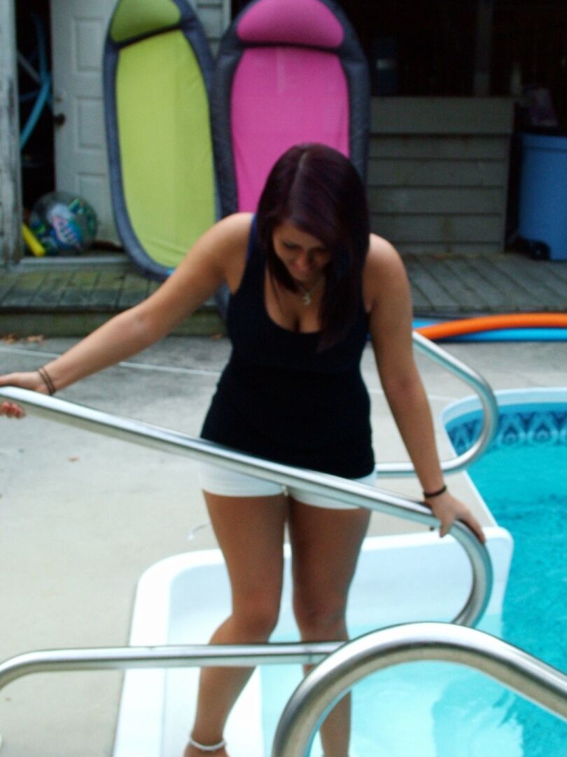 15P Garota amadora desabotoa o short depois de tirar o sutiã na piscina