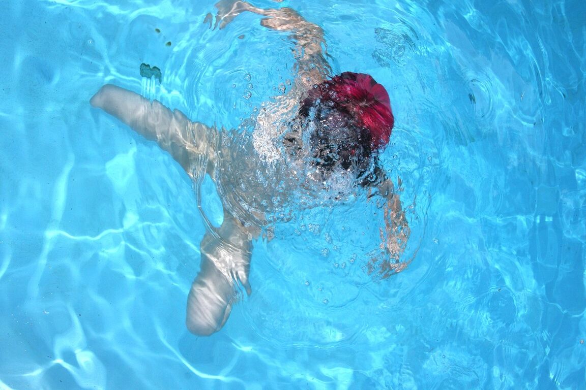 17-jähriges Punkmädchen mit rosa Haaren und perfekt geformtem Körper zieht sich am Pool aus