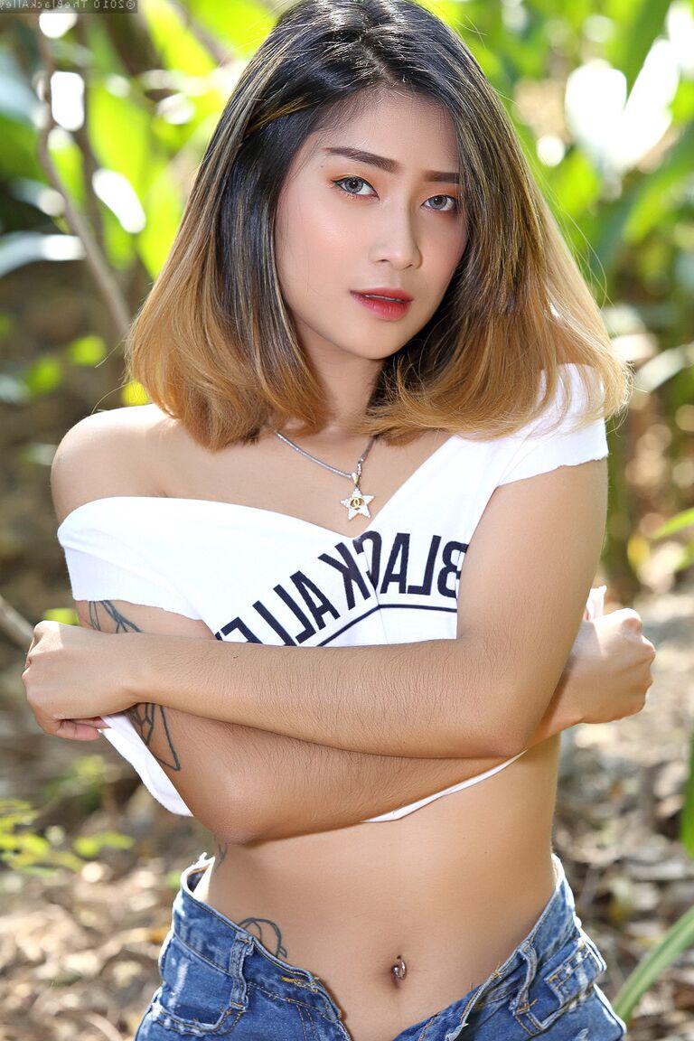 Das 16-jährige asiatische Model Apple zieht sich mit Stiefeln im Unterholz aus