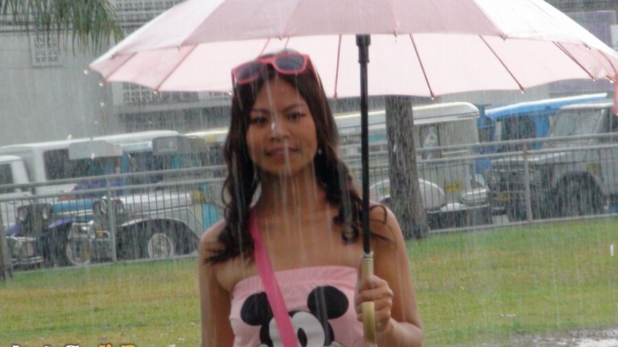 15P Asian amateur holds an umbrella in the rain before a hard POV fuck indoors