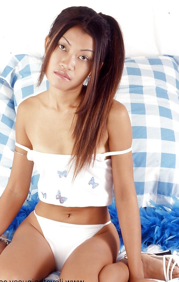 16P Fickbares asiatisches Luder in Dessous, das auf dem Bett mit seinen Spielsachen spielt