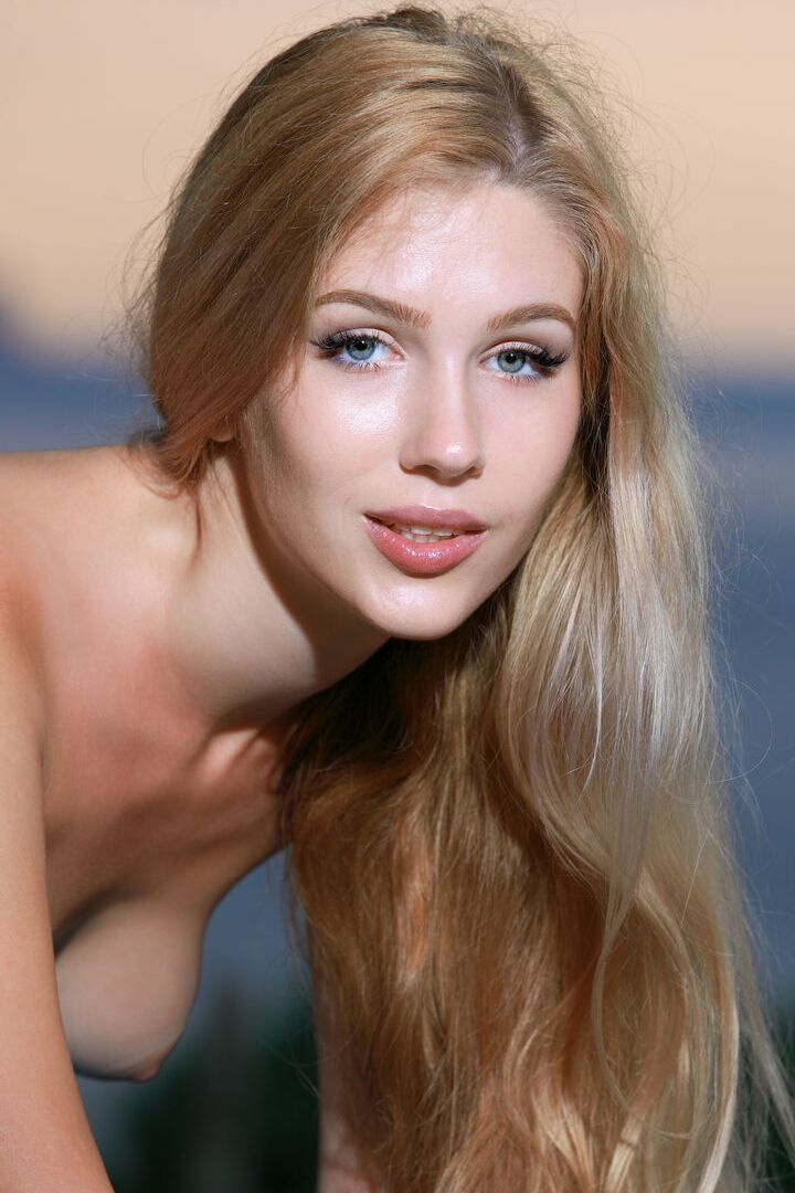 16P La douce jeune Xana D arbore des cheveux longs lors d'une séance photo totalement nue au bord de l'eau.