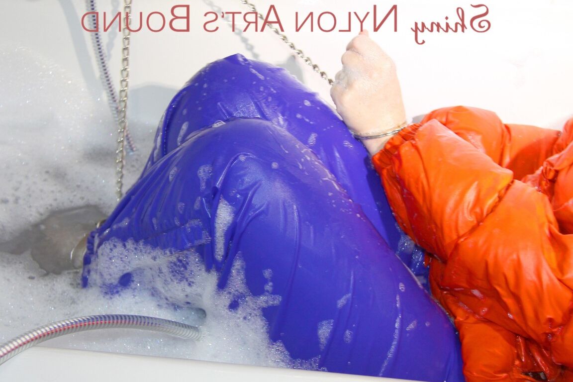 16P Jill vestindo uma calça de chuva azul sexy e uma jaqueta laranja, gravatas e mordaças