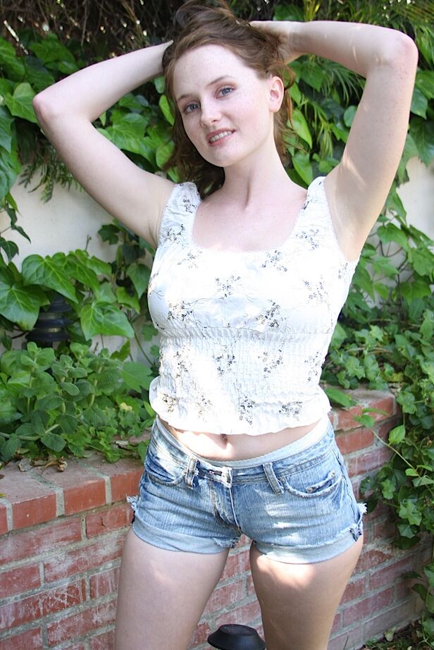 15P Menina adolescente com sardas no rosto trabalha sem shorts jeans para poses nuas
