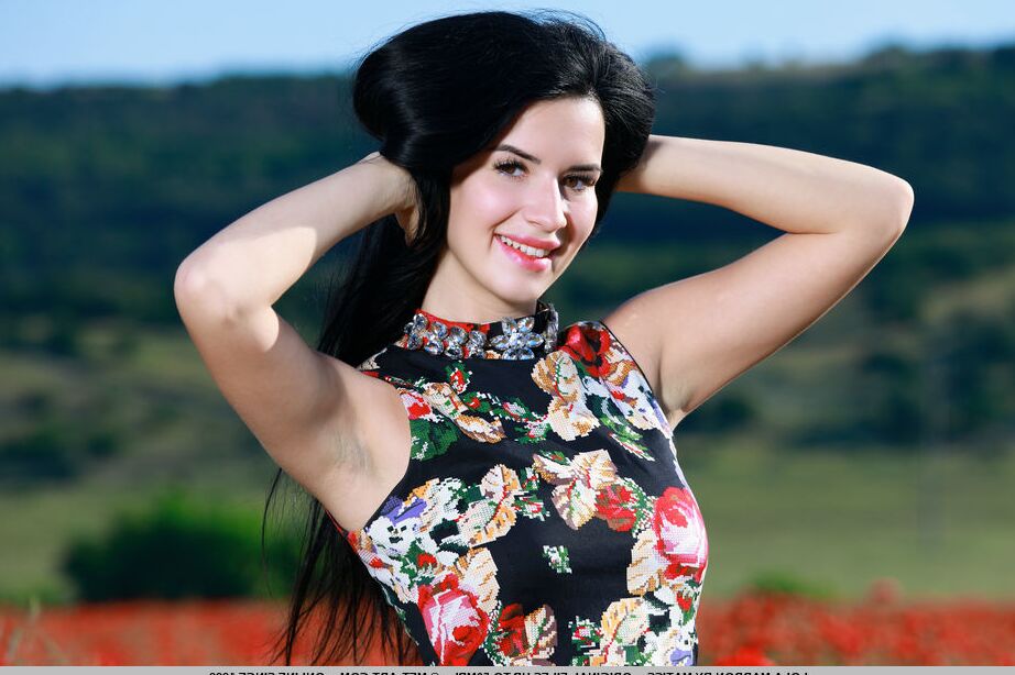 18P La joven de pelo oscuro Lola Marron se desabrocha un vestido para posar desnuda en un campo de flores