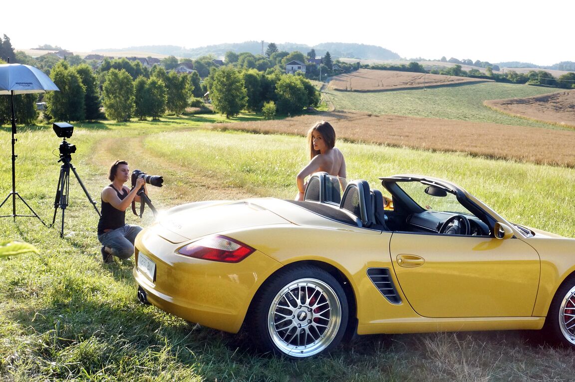13P Short Czech Little Caprice posando nua em frente a um Porsche amarelo ao ar livre