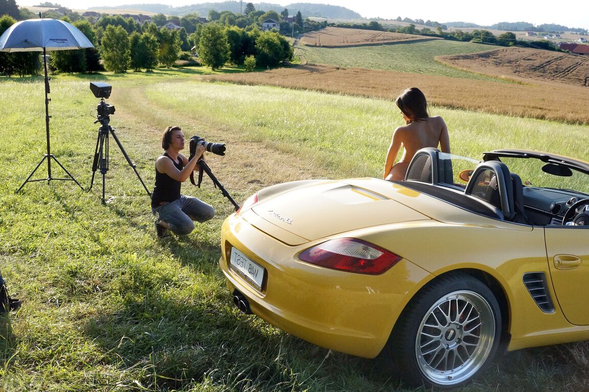 13P Short Czech Little Caprice posando nua em frente a um Porsche amarelo ao ar livre