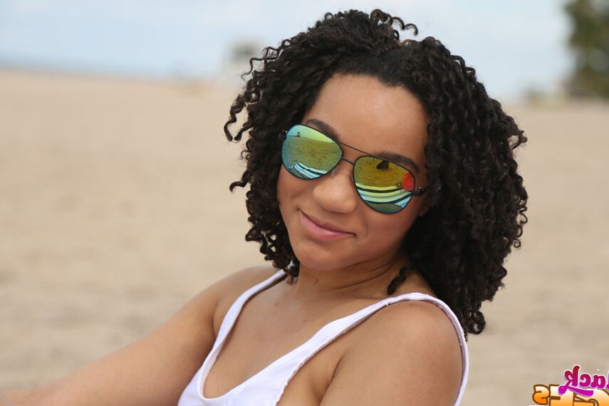 Pixie, amateur ébène 16P, pose sur la plage dans sa jolie lingerie.